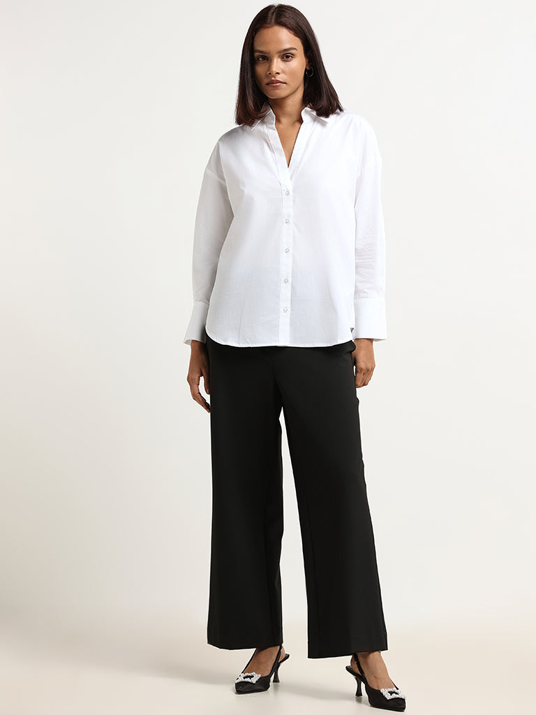 Woman posing in shirt and black pants. Beautiful young Woman posing in a white  blouse, black pants with a black belt. Black jeans close-up. Stock Photo |  Adobe Stock